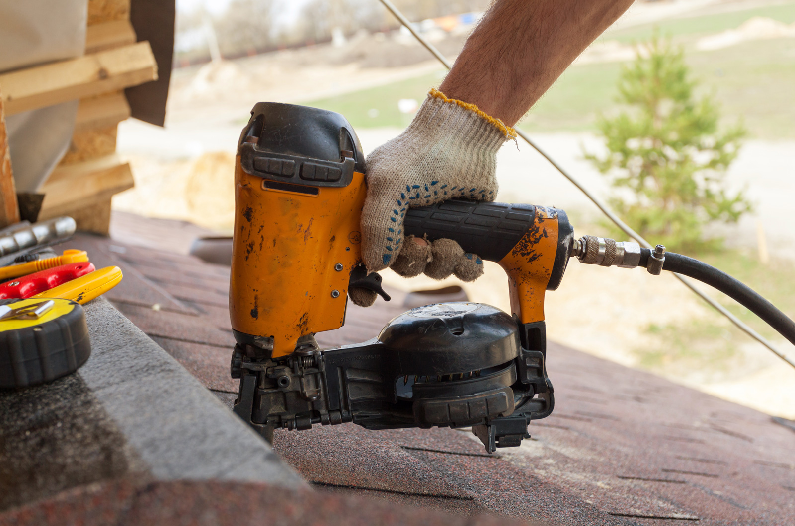 roofing-nail-gun Using nail gun to install asphalt shingles